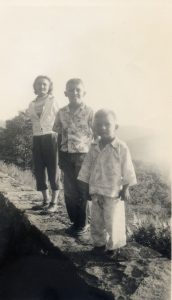 Mom, Archie, and me in pajamas. I remember I got got car sick from the curves. 